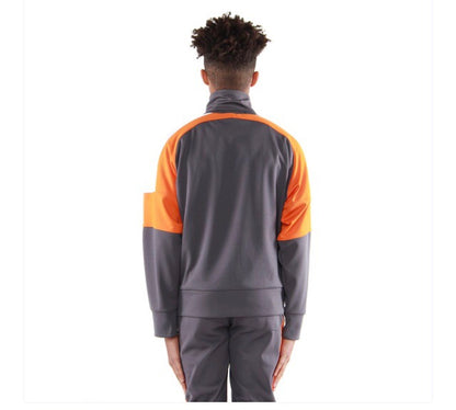 Rear view of a model wearing a grey EPTM track jacket with orange and white sleeve panels